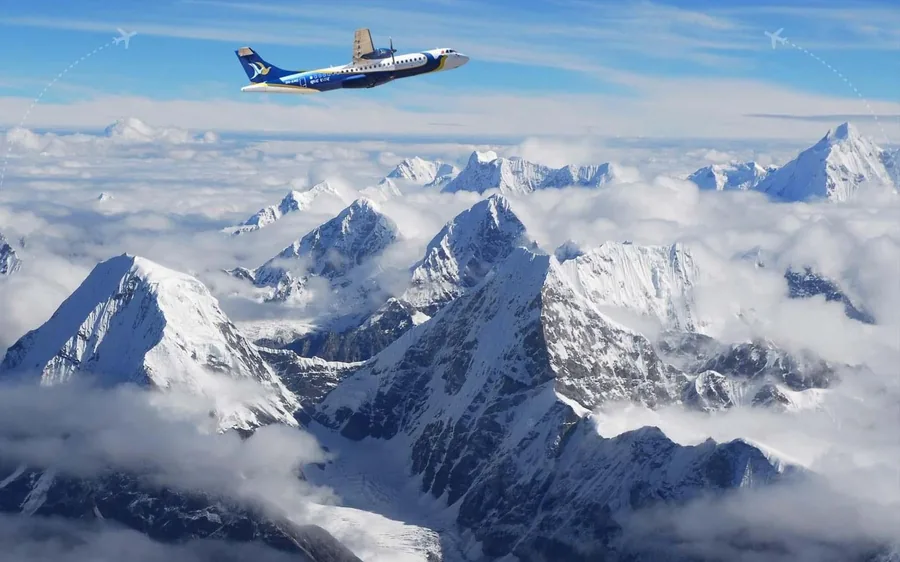 A scenic flight aircraft banking in front of a Himalayan peak