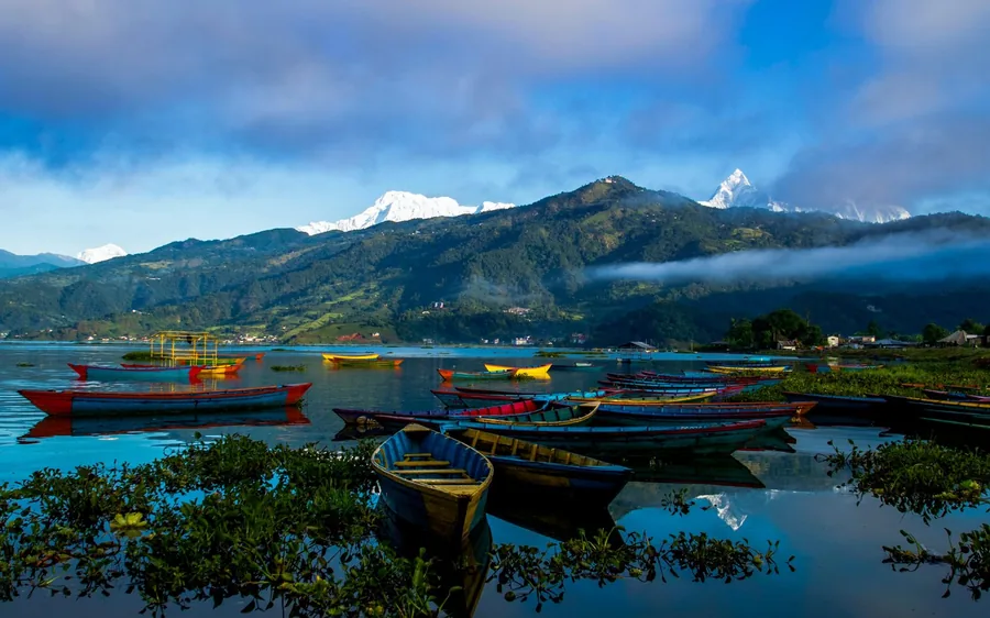 Boats on Phewa Lake at Pokhara with the mountains behind